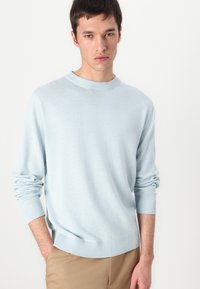 Gaiši zils viegls džemperis ar apaļu kaklu, ribinātām piedurknēm un apakšmalu. Mīksta tekstūra, garas piedurknes, viendabīga krāsa visā džemperī.