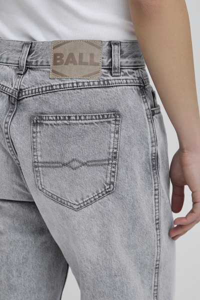Jean en denim gris avec une poche arrière présentant un motif de couture distinct et une étiquette de la marque cousue à la taille. Design classique à cinq poches.