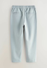 Hellblaue Hose mit elastischem Bund, ausgestattet mit zwei Gesäßtaschen und einer glatten Textur, die zum Knöchel hin schmaler wird.
