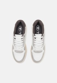 Baskets de sport blanches et grises en matériaux de daim et de cuir. Présentent des lacets, une boîte à orteils perforée et une semelle en caoutchouc. Logo sur la languette en noir.