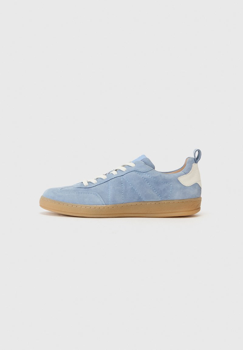Zapatilla de ante azul con acentos blancos, puntera redonda, cordones en la parte frontal y suela de goma beige, con costuras diagonales en los lados.