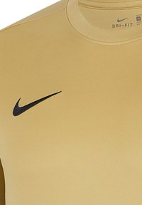 Maglietta a maniche corte Nike Dri-FIT di colore beige chiaro uniforme, con il logo swoosh nero sul petto a sinistra, realizzata in tessuto morbido e elastico.
