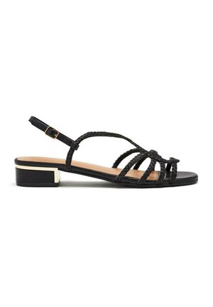 Sandalias de tacón negras con tiras trenzadas, parte superior lisa y un tacón bajo tipo bloque con un acento metálico.