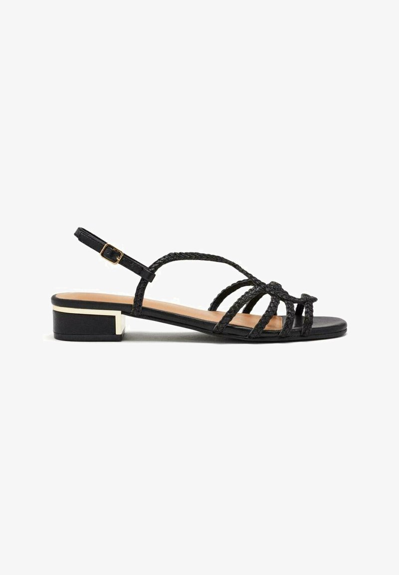 Sandalias de tacón negras con tiras trenzadas, parte superior lisa y un tacón bajo tipo bloque con un acento metálico.
