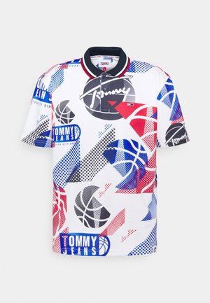 Camisa polo de manga corta blanca con un patrón geométrico multicolor que presenta gráficos de baloncesto y la marca "Tommy Jeans" en azul y rojo.