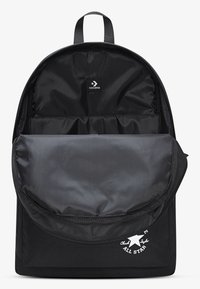 Must seljakott tekstureeritud, sileda kangaga, millel on suur esitasku, Converse'i logoga detailid ja pealiskandmisrihm.