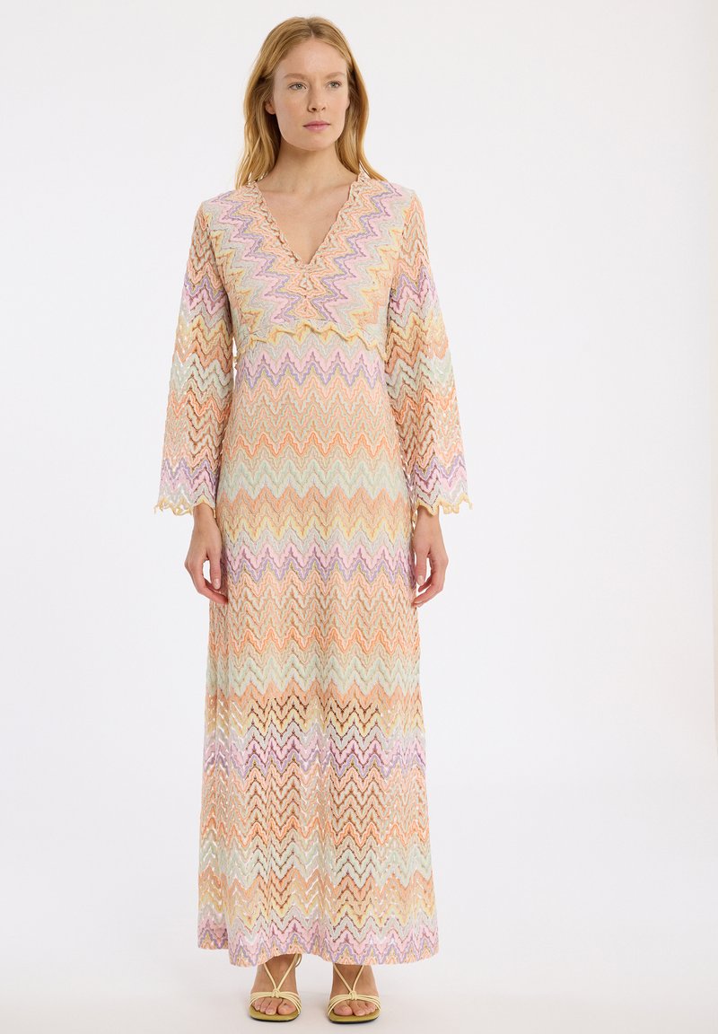 Robe maxi avec un décolleté en V, manches longues à cloche, fabriquée en tissu à motifs zigzag multicolores dans des teintes pastel, avec une coupe ample.