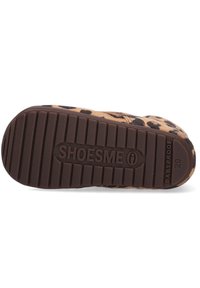 Bruine rubberen zool van peuterschoenen met een gestructureerd patroon, voorzien van een luipaardprint stof. Gemarkeerd met "SHOESME" en gelabeld als "BABYPROOF."