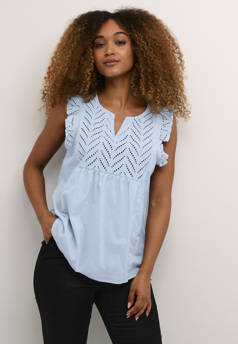 Haut sans manches bleu clair avec un design en chevron texturé et des épaules à volants ; coupe décontractée avec un décolleté en V.