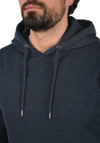 Dunkelblaues Kapuzen-Sweatshirt aus weichem, strukturiertem Stoff. Verfügt über Kordeln mit silbernen Enden und ein schlichtes, lässiges Design.