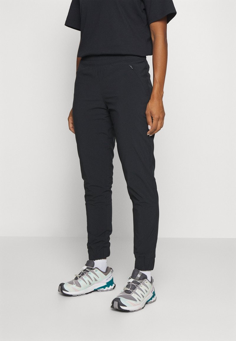 Svarta, lätta joggers med elastisk midja och smalnade muddar, i kombination med grå och teal sportskor med mesh-övre.