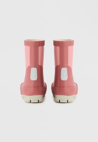 Botas de chuva de borracha rosa com acabamento brilhante, detalhes brancos na parte de trás e solas texturizadas para melhor aderência. Altura curta, interior forrado.