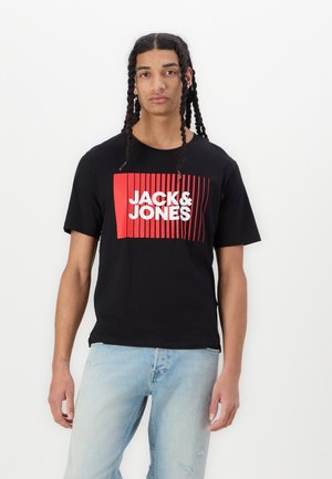 Black cotton t-shirt featuring a large red and white "JACK & JONES" graphic, set against vertical red lines. Round neckline and short sleeves.