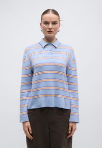 Μπλε ριγέ πόλο μπλουζάκι με κίτρινες και πορτοκαλί ρίγες, μακριά μανίκια, τριπλή σειρά κουμπιών και γιακά. Μαλακό, υφασμάτινο με υφή.