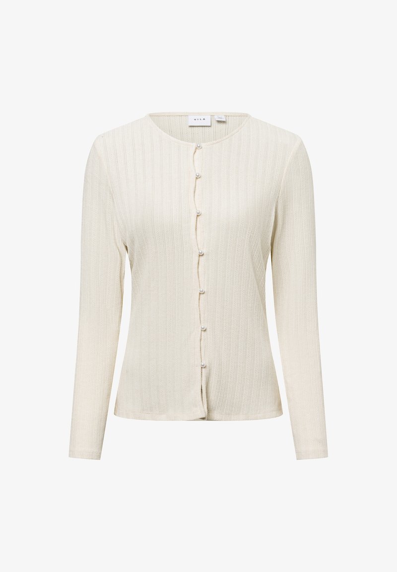 Cream ribbed long-sleeve cardigan with a rounded neckline, featuring button closure decorated with small pearl-like accents. Soft texture.