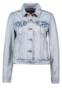 Ljust blå denimjacka med knappstängning, två bröstfickor och en spetsig krage. Tyget har en aningen sliten textur.