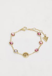 Gouden armband met een schakeldesign, ronde roze en paarse stenen, en een decoratieve cirkelvormige hanger met bloemdetail.