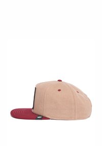 Tan suede baseball cap with a maroon flat brim. Features a black logo patch on the front and contrasting red stitching.