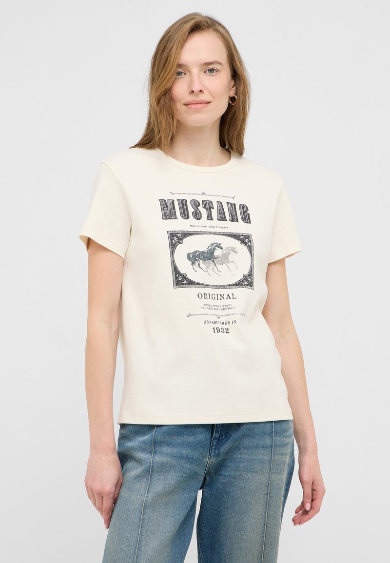 Beżowa bawełniana koszulka z krótkim rękawem, z nadrukiem graficznym przedstawiającym galopujące konie w stylu vintage oraz napisem "MUSTANG".