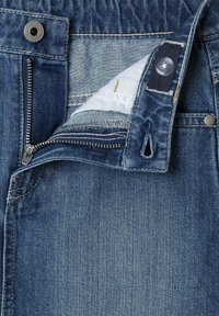 Jeans iz denima z zadrgo in gumbom, v srednjem pranju. Vidna podrobnost neobdelanega robu in mehak notranji podloga.