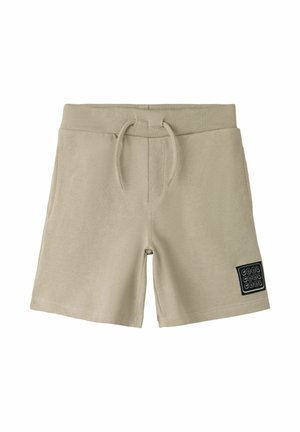 Short en coton beige avec taille élastique, cordon de serrage, poches latérales et écusson noir indiquant "COOL COOL COOL" sur la jambe gauche.