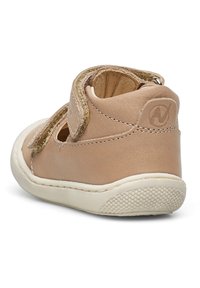 Beige kožená bota s páskem na suchý zip, zaoblenou špičkou a strukturovanou gumovou podrážkou. Obsahuje výřezy pro prodyšnost a minimální šití.