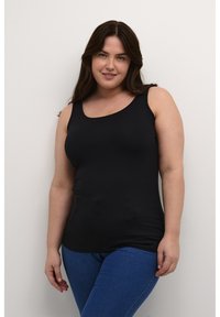 Top negro sin mangas de tela elástica con escote redondeado, combinado con jeans azules. Textura suave.
