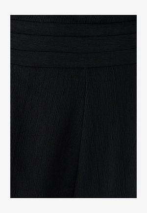 Melnas plisētās audums ar teksturētu virsmu. Jostele ir gluda, apvienojoties ar nedaudz izplesto apģērba dizainu.