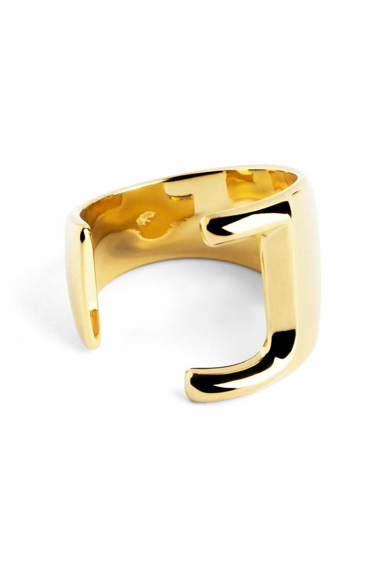 Anello in metallo dorato con design a banda aperta, caratterizzato da una forma quadrata e un'accattivante accentatura a "J" sul davanti. Superficie liscia e riflettente.
