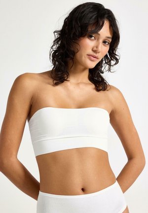 Top bandeau bianco senza spalline realizzato in tessuto morbido, con design aderente e costruzione senza cuciture, abbinato a slip bianchi coordinati.