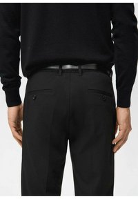 Czarne, dopasowane spodnie o gładkiej fakturze, z dwoma tylnymi kieszeniami oraz paskiem z błyszczącego materiału. Talia ma szlufki na pasek.