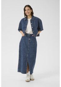 Jeans jakna s kratkimi rokavi in gumbnim zapiranjem, združena z dolgo jeans krilo z vrhnjim razporkom, obe v temno modri barvi.