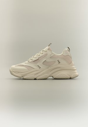 Basket beige épaisse avec une semelle texturée épaisse, dessus en mesh et cuir, fermeture à lacets à l'avant et languettes sur la languette et le talon.