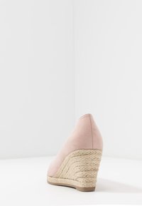 Wedge hak schoen van zacht roze suede met een getextureerd geweven jute platform. Kenmerkt zich door een puntige neus en een gladde afwerking.