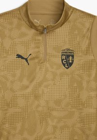 Beige atletisk zip-up top med et subtilt prikket mønster, Puma-logo i sort og Racing Club de Lens-emblem på venstre bryst.
