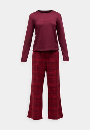 Camisa de manga larga color marrón con logo bordado, combinada con pantalones de cuadros de pierna ancha en tonos rojos. Material de mezcla de algodón, textura suave.