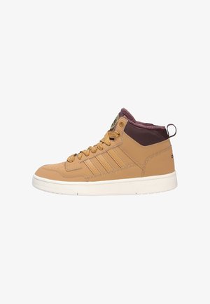 Beige Mid-Top Sneaker mit einem strukturierten Leder-Obermaterial, kontrastierendem braunen Kragen, sechs Ösen-Schnürung und einer weißen Gummisohle.