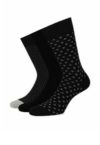 Trzy pary skarpetek: dwie gładkie czarne, jedna czarna w białe kropki, a jedna z szarym palcem. Wykonane na drutach, długość do połowy łydki.