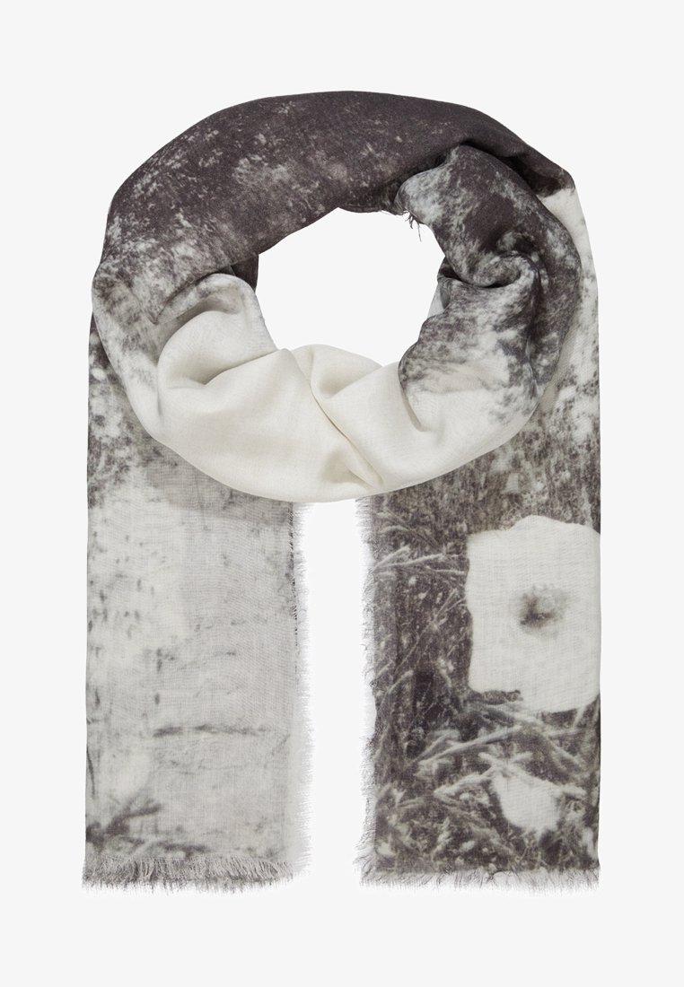 Écharpe douce avec des motifs abstraits et floraux noirs, blancs et gris, pliée légèrement avec des bords frangés.