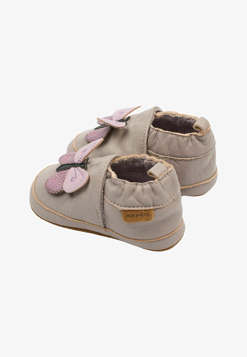 Chaussures en cuir gris clair avec des accents papillon roses et des ouvertures élastiques. Finition texturée notable et semelle douce et flexible pour le confort.