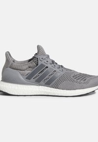 Šedá běžecká bota s prodyšným síťovaným svrškem, designem se třemi pruhy po stranách a bílou polstrovanou podrážkou.