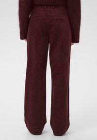 Bordeaux corduroy broek met brede pijpen, een gestructureerd oppervlak en twee achterzakken, met een klassieke tailleband en riemlussen.
