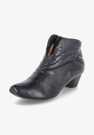 Bottines en cuir noir avec un design matelassé, bout pointu et petit talon en bois. Fermeture éclair sur le côté pour un enfilage facile. Texture lisse.