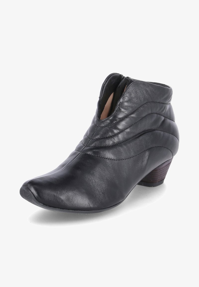 Botines de cuero negro con diseño acolchado, punta afilada y pequeño tacón de madera. Cremallera lateral para facilitar su uso. Textura suave.