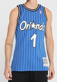 Maillot de basket-ball bleu avec des rayures verticales blanches, arborant le logo "Orlando" et le numéro "1" en police blanche, un col noir côtelé et une étiquette.