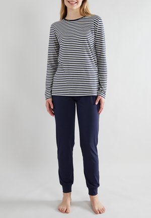 Langarm, marineblauw en wit gestreept shirt gecombineerd met effen marineblauwe broek. Zachte stof, relaxte pasvorm en ribbels aan de manchetten van de mouwen en de broek.