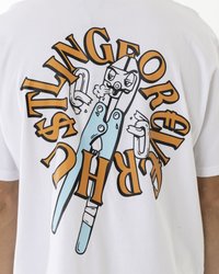 Weißes Baumwoll-T-Shirt mit einem zentralen Grafikdesign von blauen Zangen und orangefarbener Schrift. Das Design enthält cartoonhafte Gesichter und Dollarsymbole.