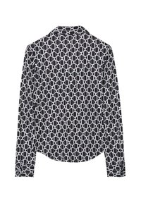 Long-sleeve blouse in black and white, featuring a circular pattern. Soft fabric with buttoned cuffs and a curved hemline.