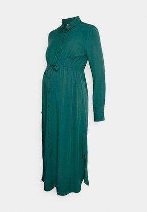 Vestido de maternidade verde com frente abotoada, colarinho, mangas longas, cintura com cordão e fendas laterais. Tecido suave e leve.
