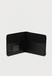 Crna novčanica od teksturirane tkanine, sadrži više utora za kartice, glatke dijelove i zlatni logo akcent. Kompaktni i dvostruki dizajn.